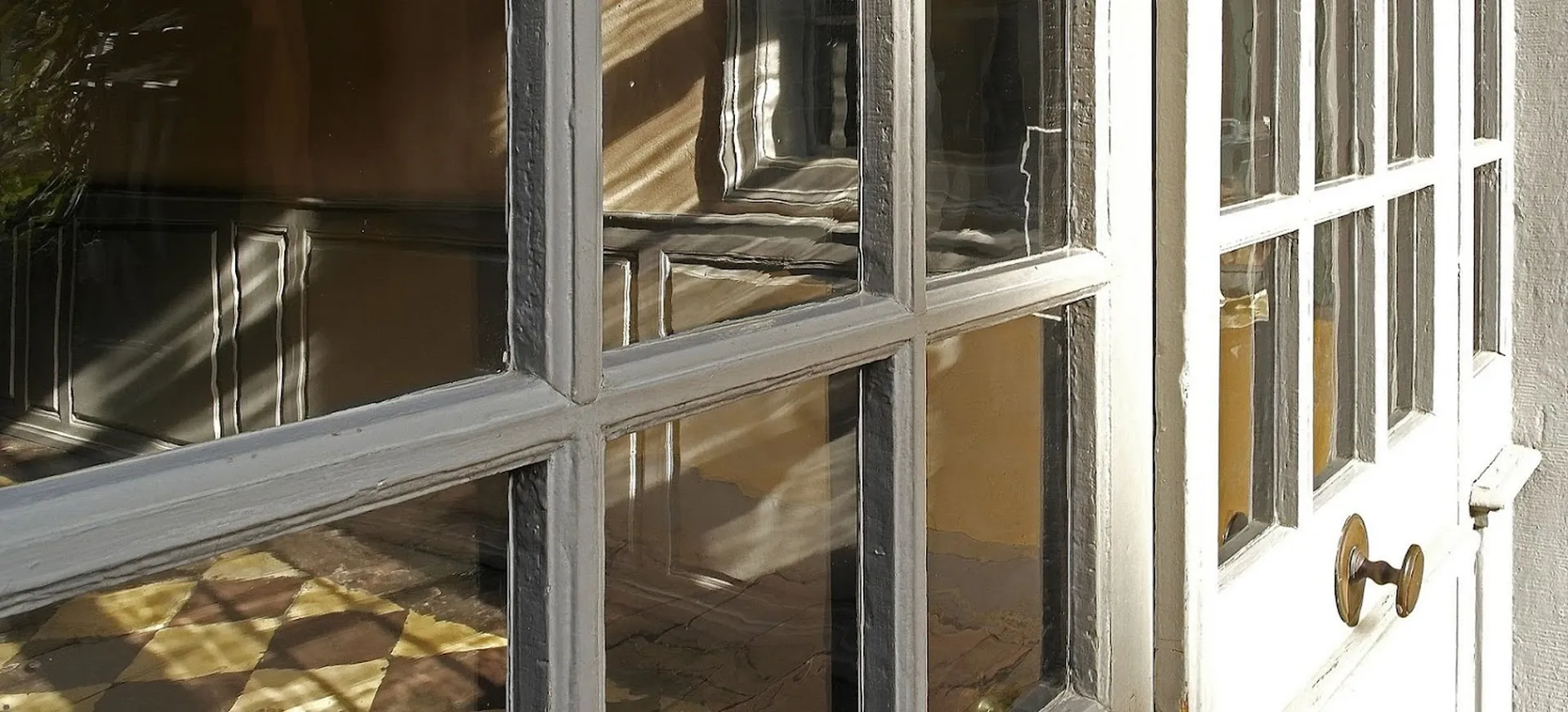 Light falls through the Goethe glass panes of a door from the courtyard into the museum corridor.