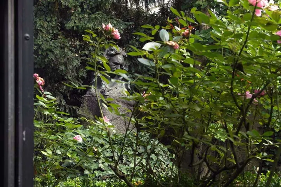 View from the window of the chamber music hall into the romantic garden of the Beethoven-Haus. The large bronze bust of the composer can be seen between the roses, looking pensive and introspective.