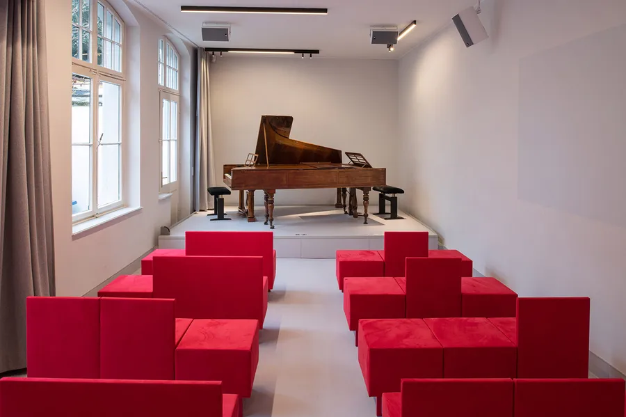 The museum's bright little music room is equipped with two historical fortepianos and pink-coloured movable seat cushions.